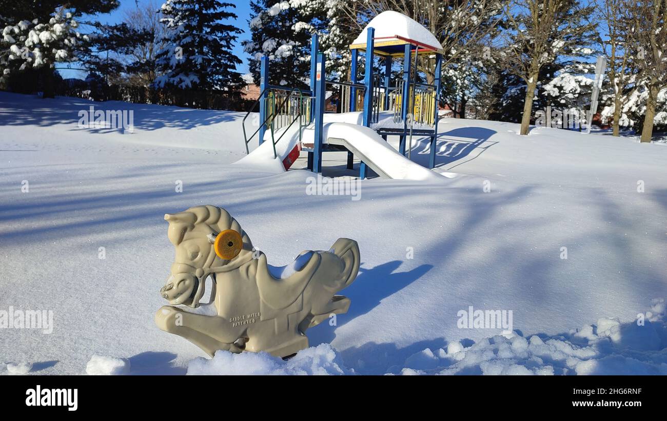 Terrain de jeu en hiver.Zone de loisirs d'hiver pour les enfants.Météo enneigée.L'équipement de l'aire de jeux pour enfants est recouvert de neige avec des arbres en arrière-plan Banque D'Images