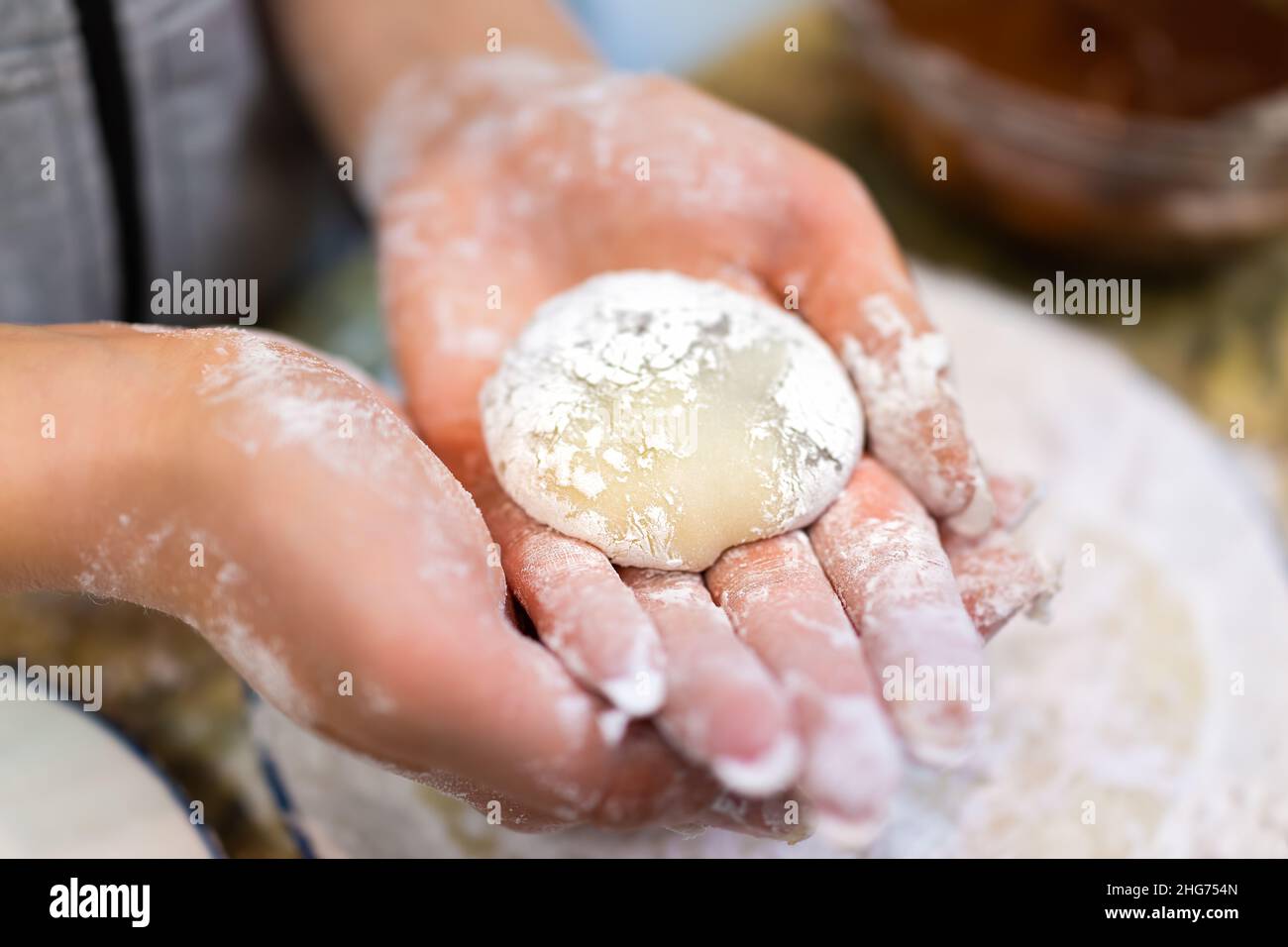 Femme main façonnant tenant faisant un morceau de cuisine de mochi collant daifuku gâteau japonais de riz avec la farine d'amidon comme dessert traditionnel Banque D'Images