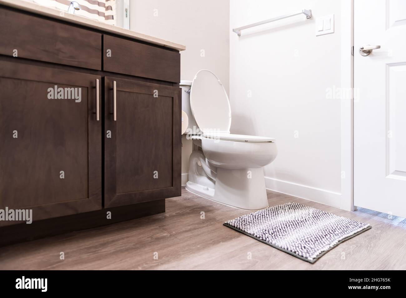 Vide salle de bain intérieur personne dans nouveau moderne appartement de luxe maison et toilette blanche avec tapis et armoires de porte vue à angle bas Banque D'Images