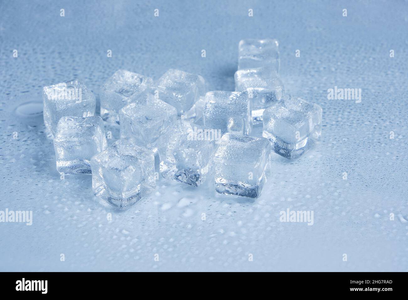 Les glaçons sont recouverts de gouttelettes d'eau sur fond bleu clair Banque D'Images
