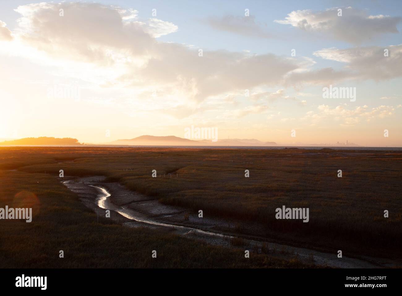 Voie navigable dans les zones humides avec chaîne de montagnes à Sunset, CA Banque D'Images