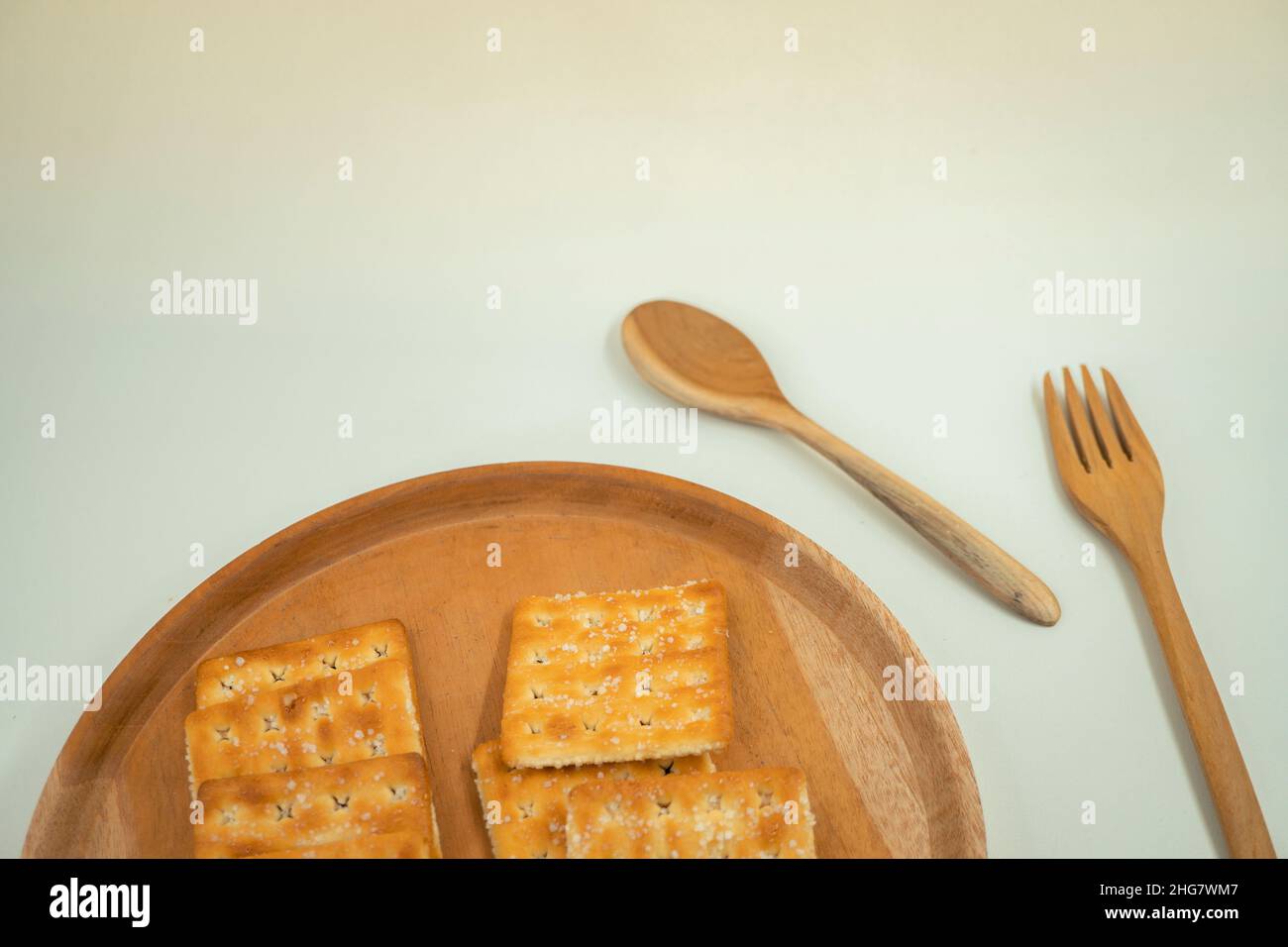 photo rapprochée de l'emballage en biscuit sur la plaque en bois, la fourchette et la cuillère, avec fond blanc.Ces photos sont parfaites pour la brochure alimentaire. Banque D'Images
