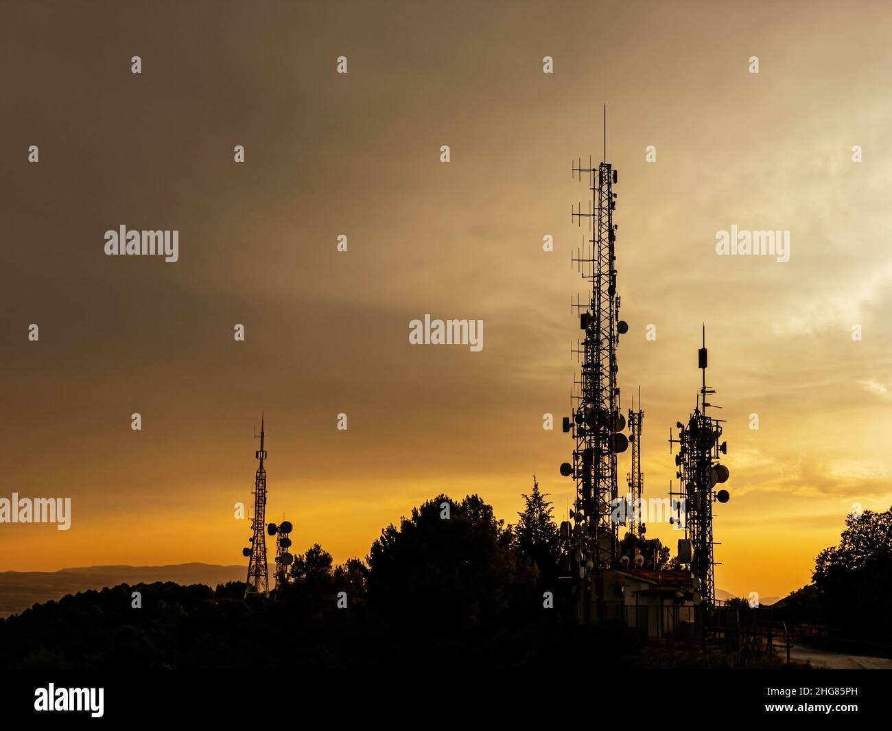 Antennes de télécommunication avec coucher de soleil sur fond. Banque D'Images