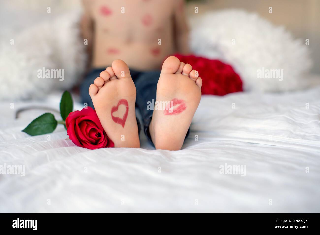 Les pieds des tout-petits avec un baiser rouge à lèvres et un coeur et une  rose rouge à côté de lui, se concentrent sur les pieds Photo Stock - Alamy