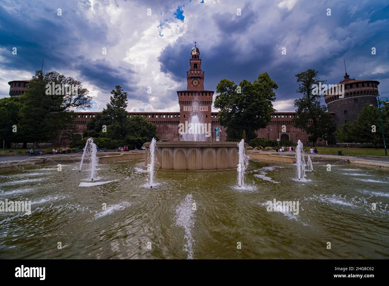 Le Castello Sforzesco, le château de Sforza, situé sur la Piazza Castello, vu au-dessus d'une fontaine, un orage arrive. Banque D'Images