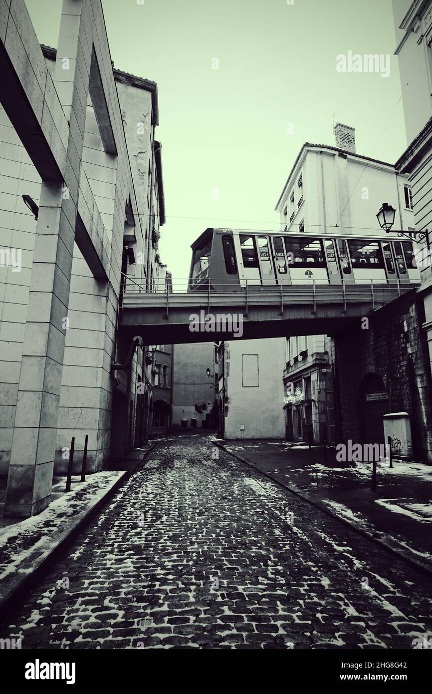 Tramway descendant de la colline de Fourvière dans le Vieux Lyon, en un jour enneigé, noir et blanc Banque D'Images