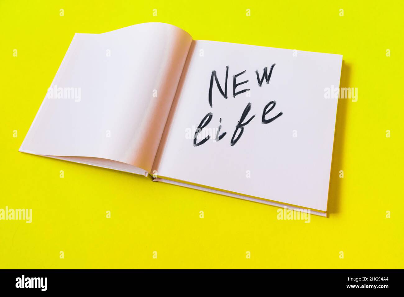 Nouvelle vie.Bloc-notes avec des pages vierges sur fond jaune. Banque D'Images