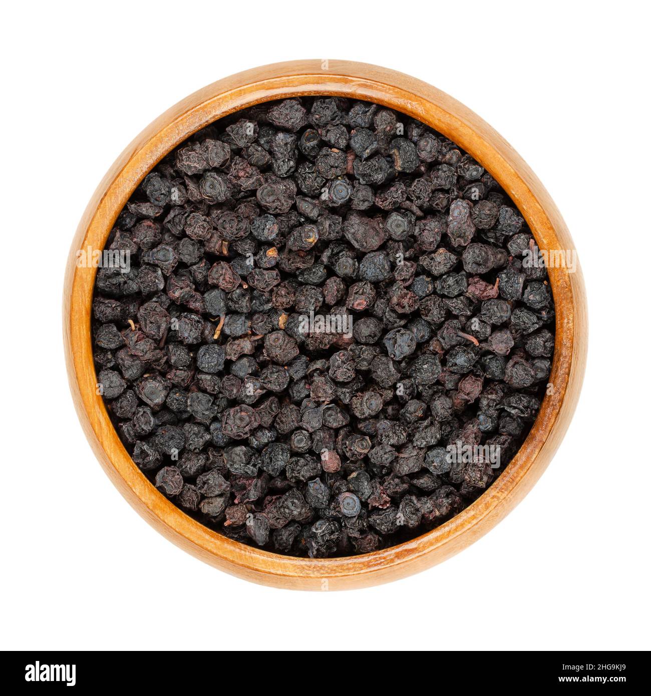 Myrtilles séchées, bleuets européens, dans un bol en bois.Fruits mûrs et crus de Vaccinium myrtillus, également connu sous le nom de blaeberry et de wimberry. Banque D'Images