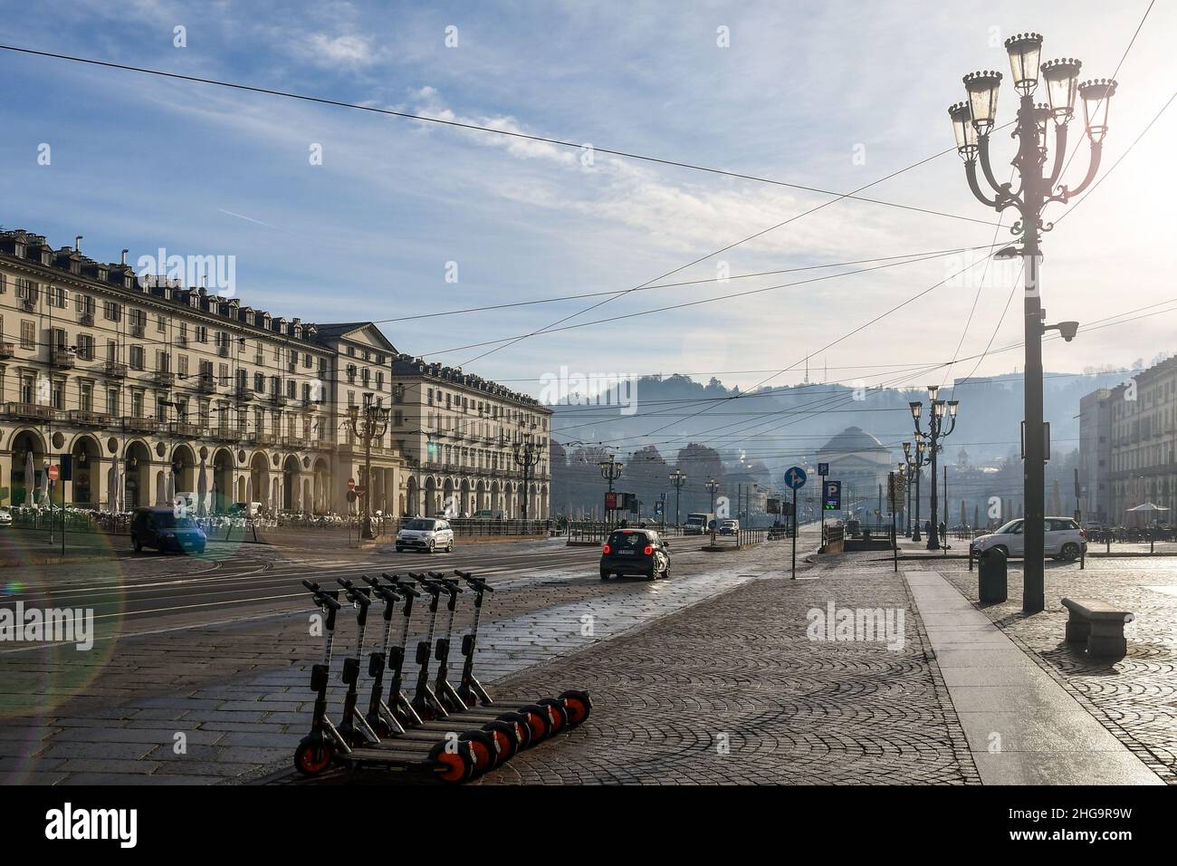 Vue à contre-jour de la Piazza Vittorio Veneto avec location de scooters électriques et des fusées éclairantes d'objectif en hiver, Turin, Piémont, Italie Banque D'Images