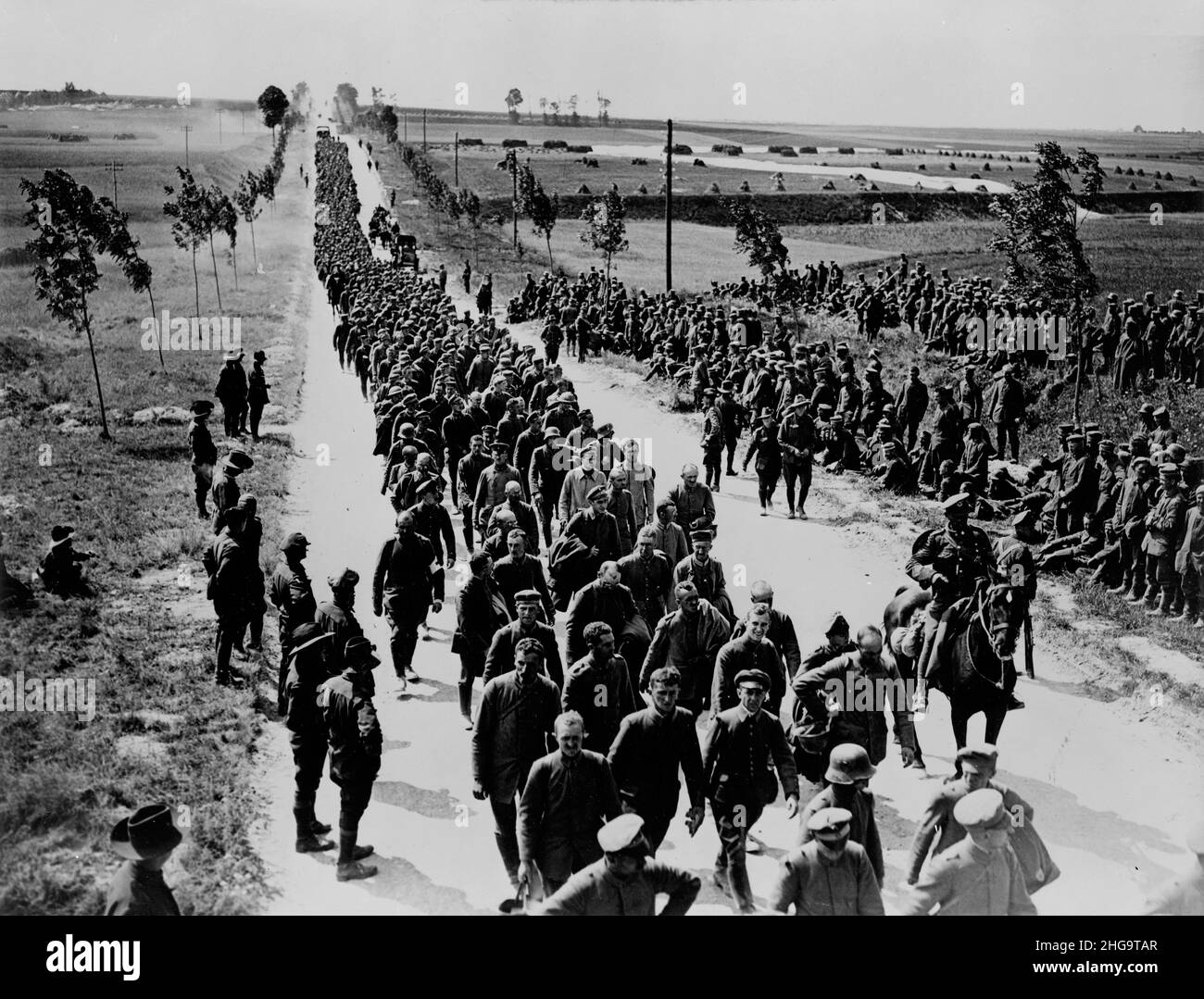 Une photo vintage vers 1918 d'une colonne de prisonniers de guerre allemands qui sont en tête de la ligne de front en captivité par des soldats australiens sur le front occidental en France Banque D'Images