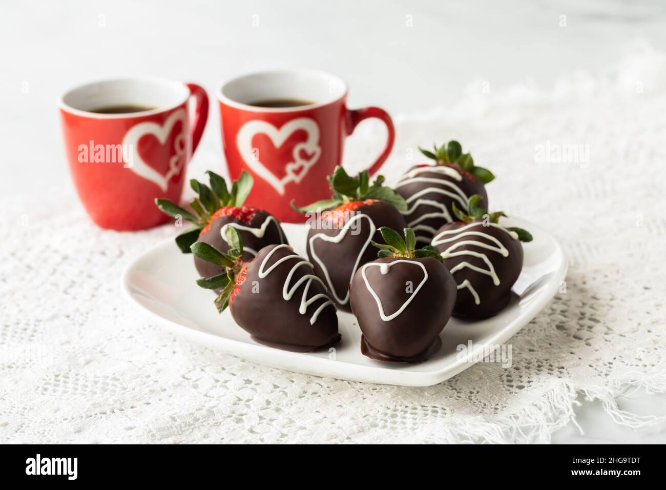 Fraises enrobées de chocolat décorées à partager le jour de la Saint-Valentin. Banque D'Images