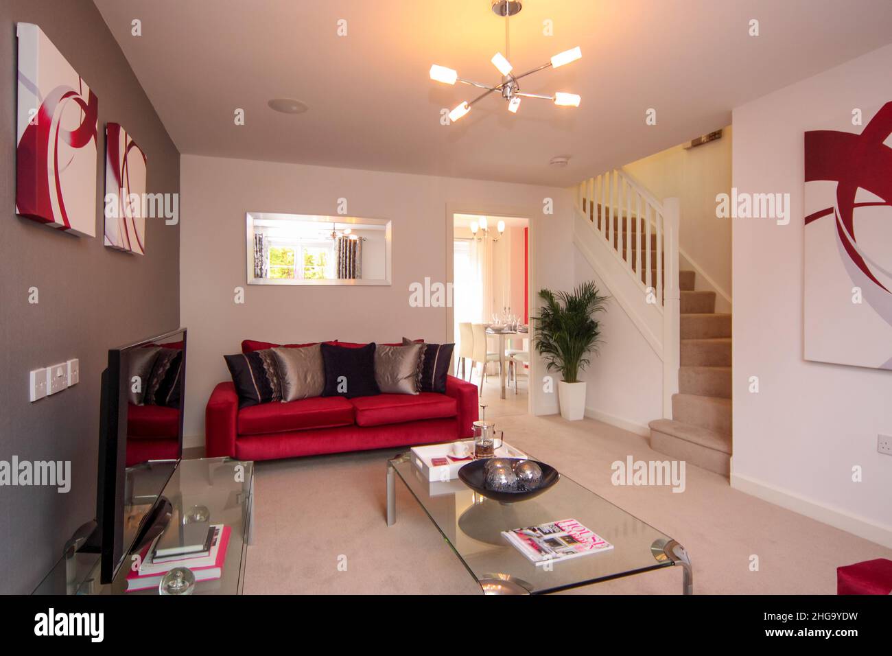 Salon, escalier au deuxième étage, couleurs rouge foncé, canapé, table basse en verre Banque D'Images