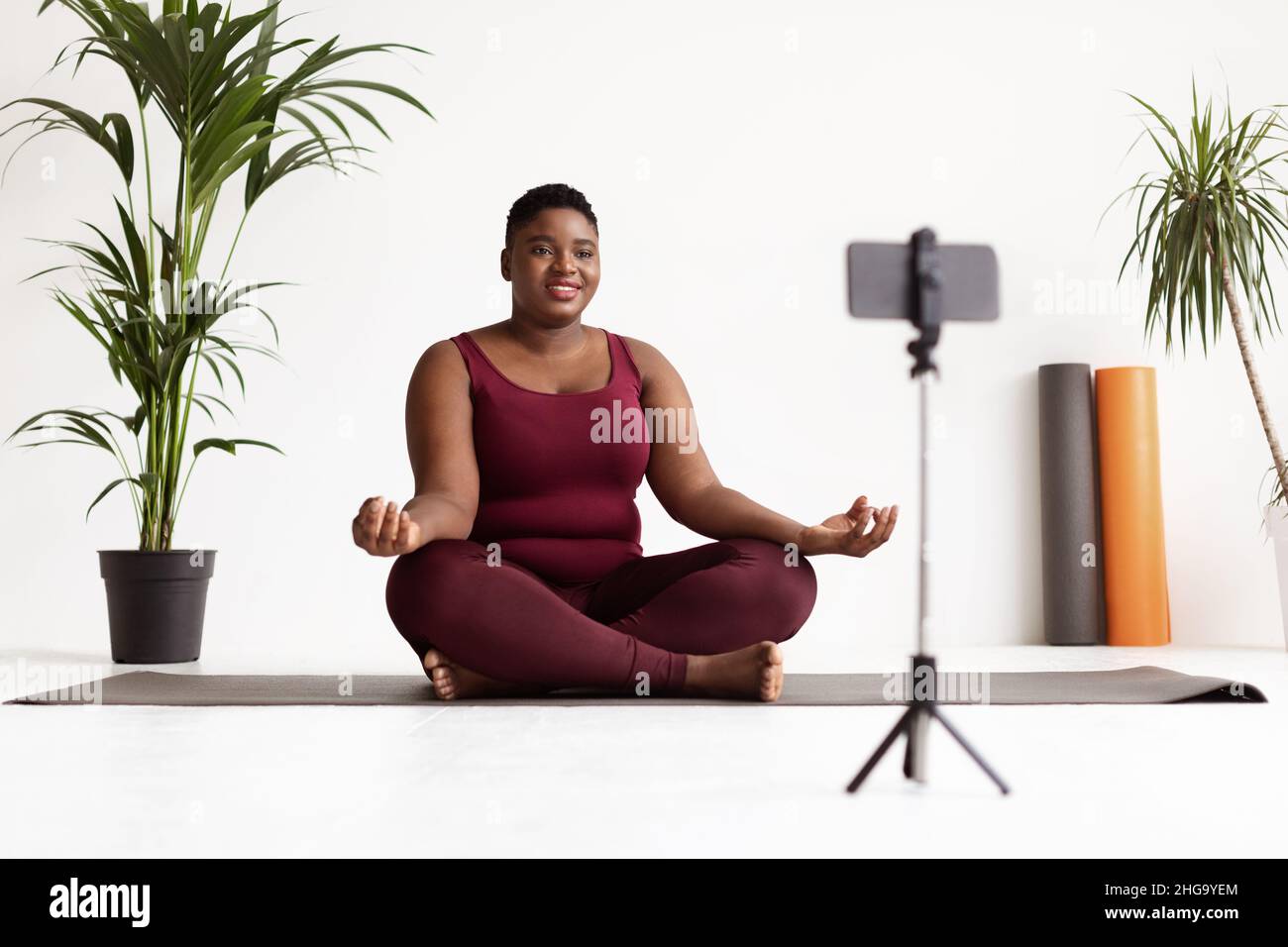 Une dame noire et paisible participe à un cours de yoga en ligne Banque D'Images