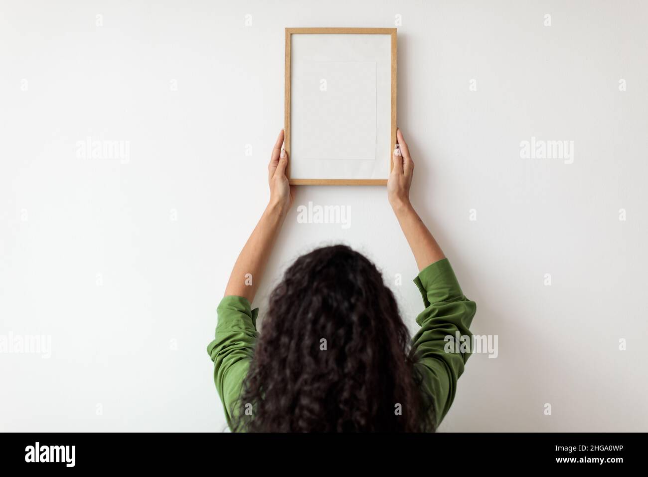 Vue arrière du cadre photo suspendu de la dame sur le mur à l'intérieur Banque D'Images