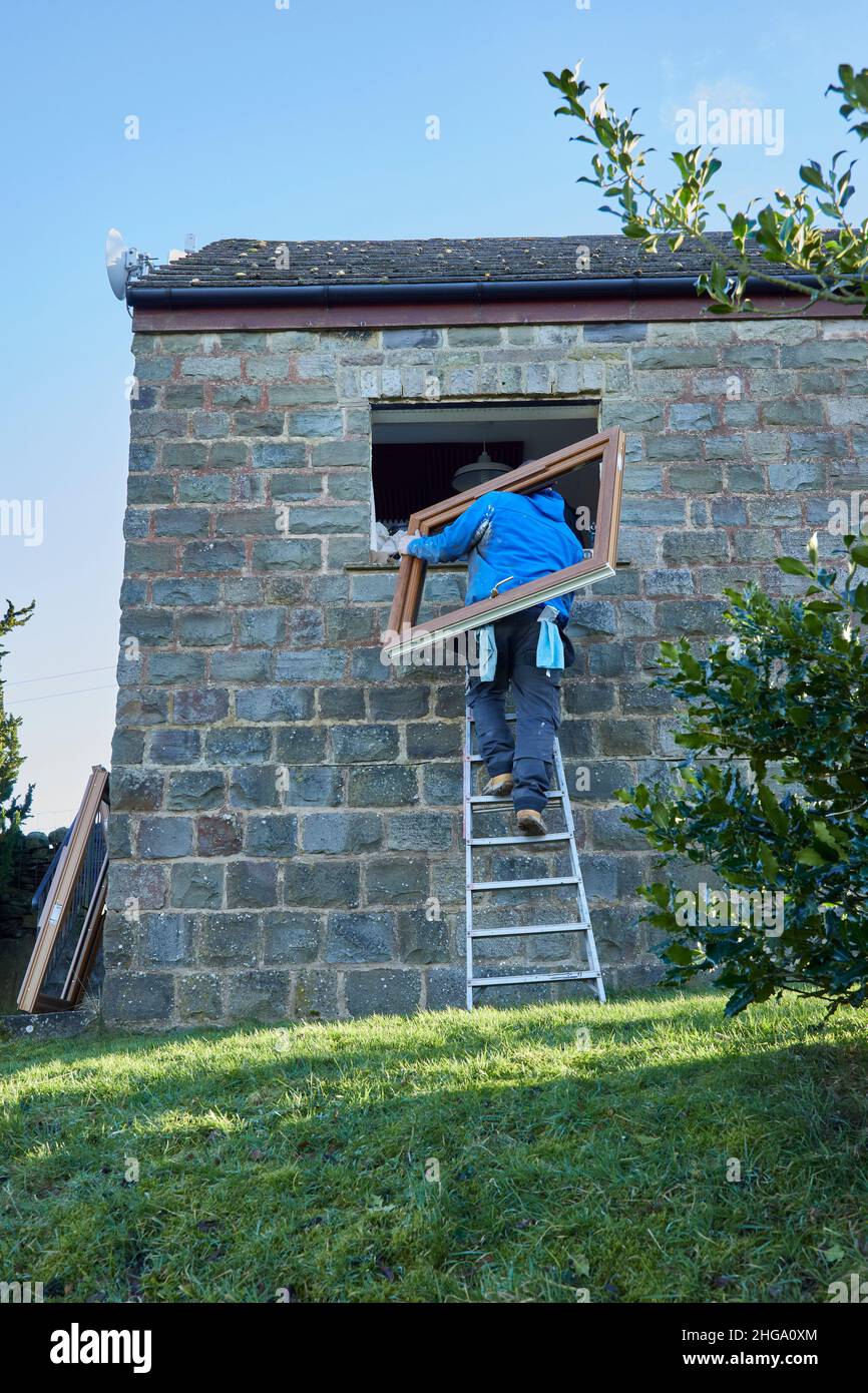 Des ouvriers qui ont installé des fenêtres de remplacement dans la construction rurale Banque D'Images