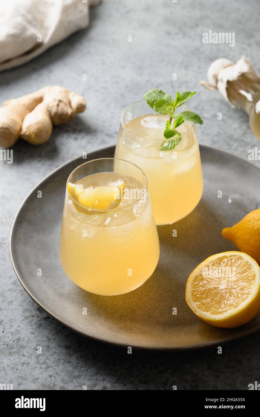 Heathy bio probiotique fait maison Kombucha dans des verres avec citron et gingembre sur fond gris avec espace de copie. Gros plan. Format vertical. Banque D'Images