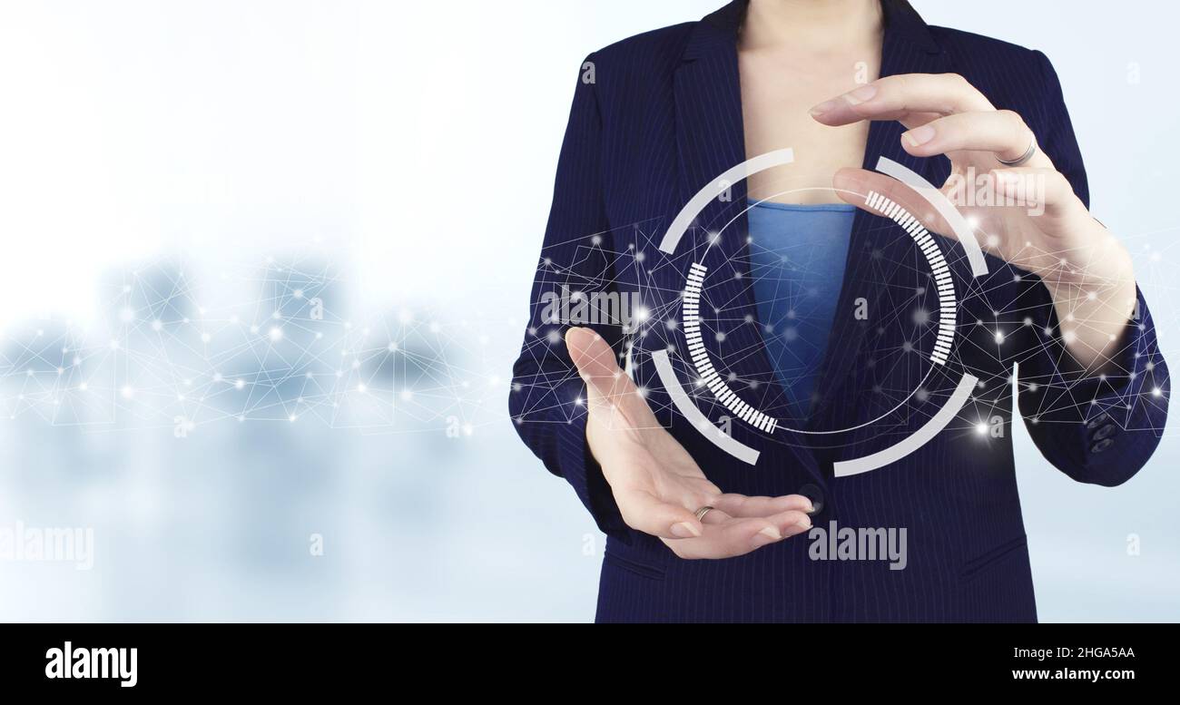 Concept de technologie de communication et d'innovation de réseau d'entreprise.Icône de diagramme circulaire holographique virtuel à deux mains avec arrière-plan légèrement flou Banque D'Images
