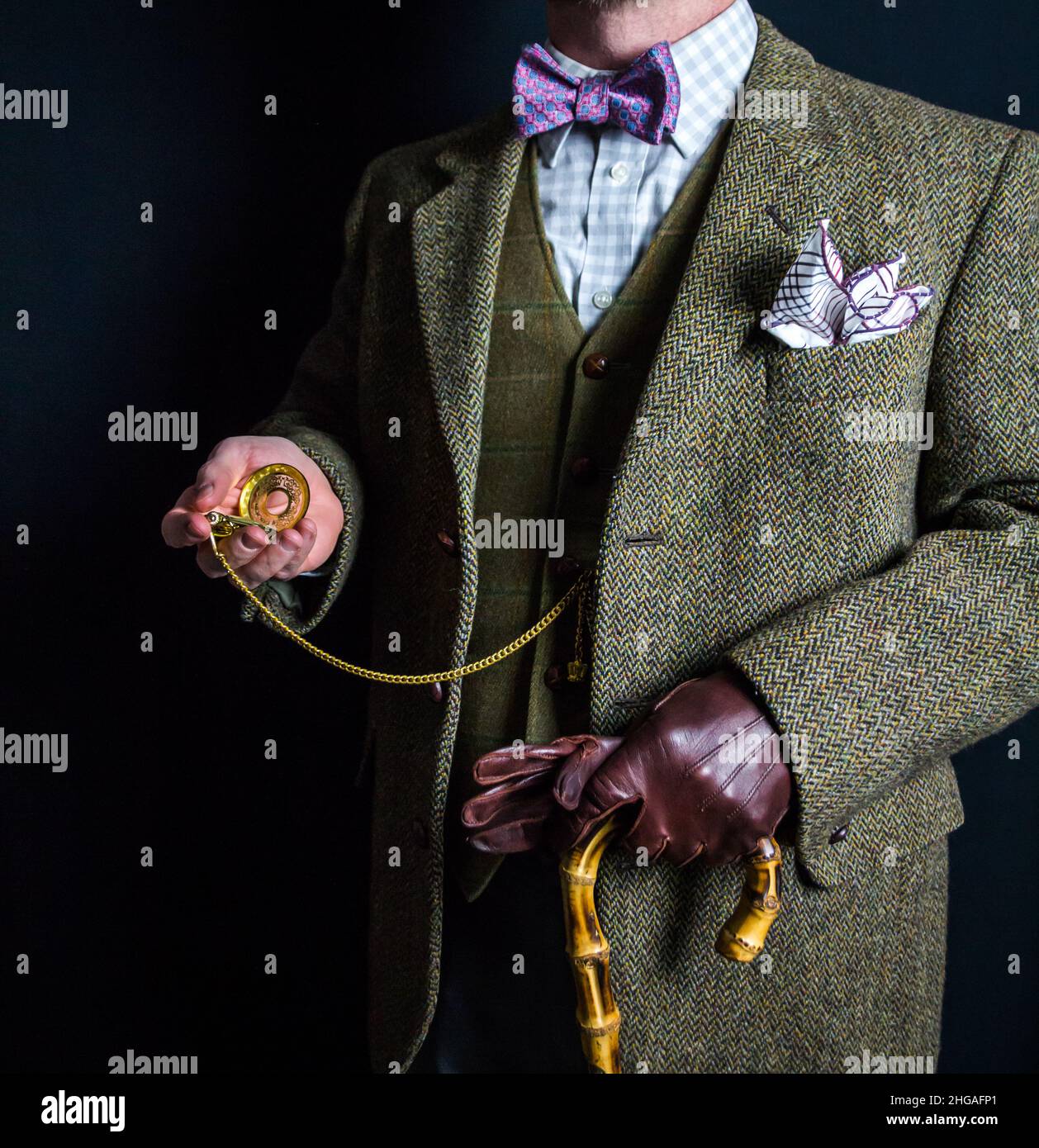 Portrait d'un homme anglais en costume tweed tenant une montre de poche dorée.Style vintage et mode rétro de gentleman britannique. Banque D'Images