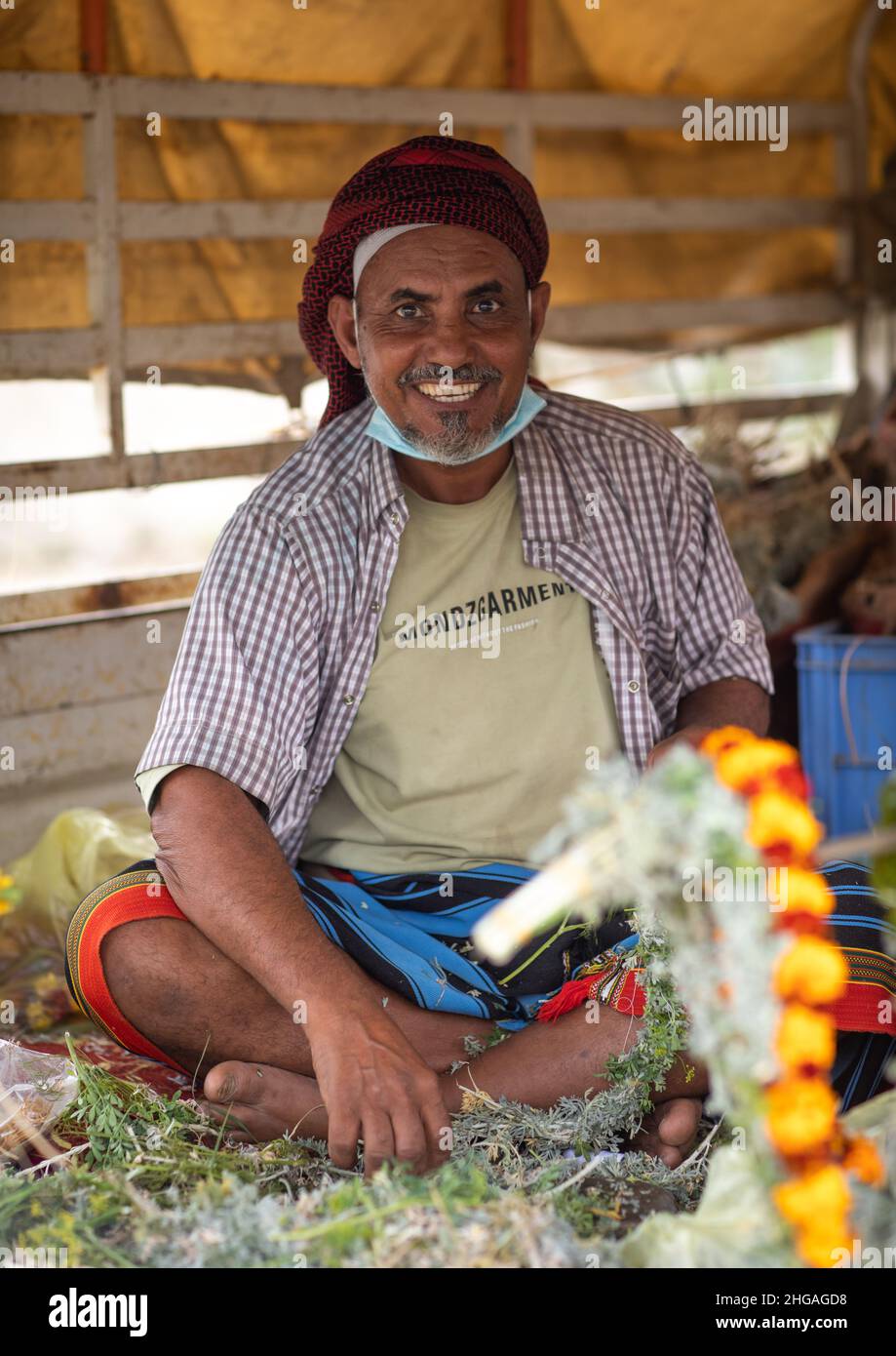 Homme vendant des couronnes florales dans un marché, province de Jazan, Addayer, Arabie Saoudite Banque D'Images