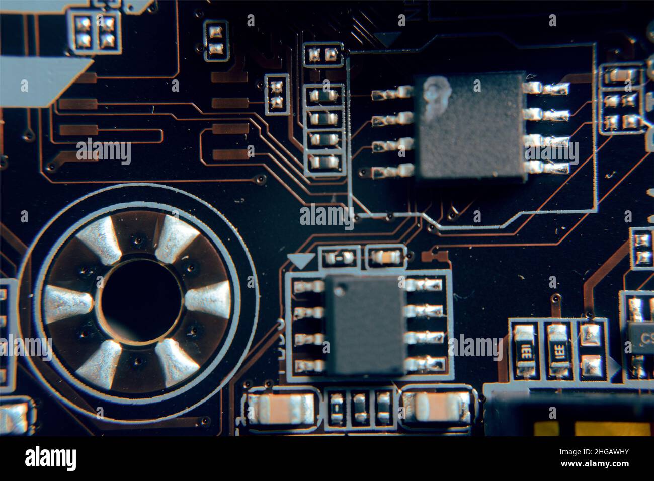 Gros plan.Jeune homme en train de réparer la carte mère d'un PC.Atelier de réparation.Utiliser des outils.Matériel informatique.Loupe.Fer à souder.Périphérique numérique Banque D'Images