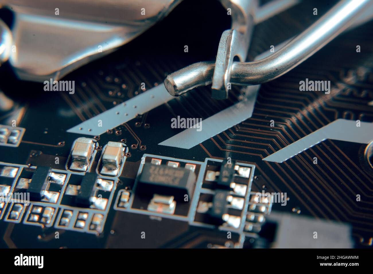 Gros plan.Jeune homme en train de réparer la carte mère d'un PC.Atelier de réparation.Utiliser des outils.Matériel informatique.Loupe.Fer à souder.Périphérique numérique Banque D'Images