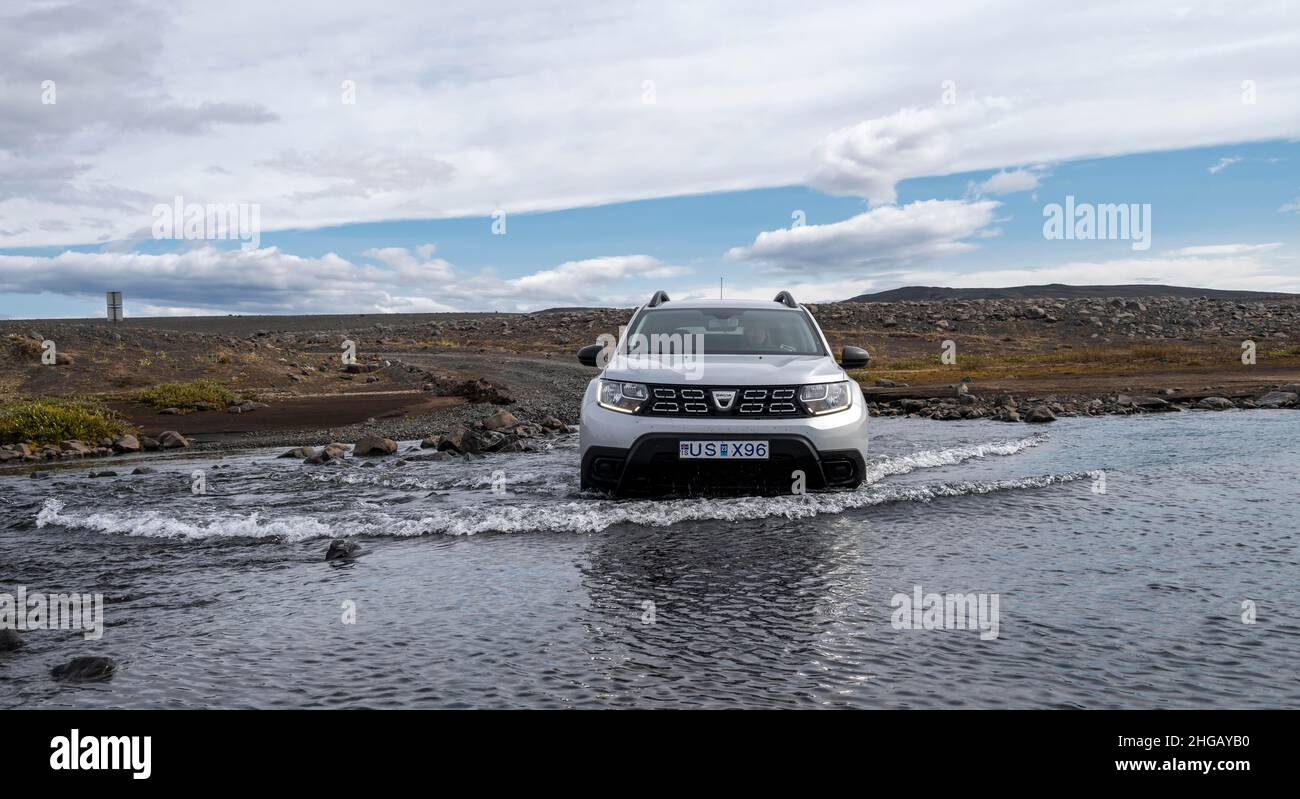 Dacia Duster 4x4 voiture traversant une rivière, ford, route de gravier, paysage stérile, Islandais Highlands,Islande Banque D'Images