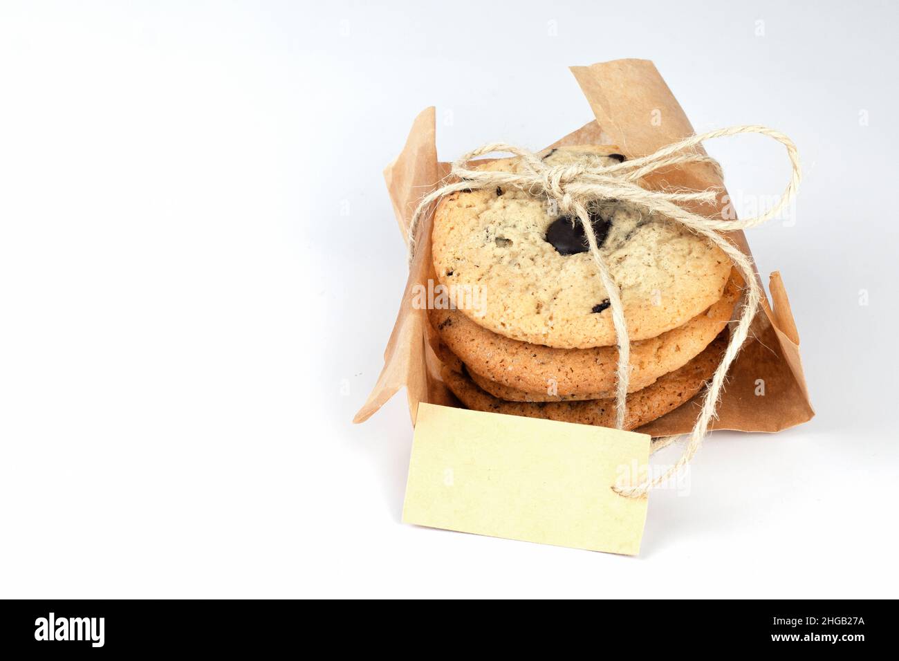 Biscuits au chocolat doux en papier kraft sur fond blanc.Concept de livraison à emporter romantique.Partie de l'ensemble. Banque D'Images