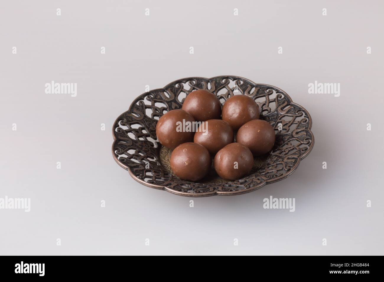 Boules de bonbons au chocolat.Délicieux dessert sur une assiette sur fond clair.Sucreries sur une soucoupe orientale sculptée. Banque D'Images