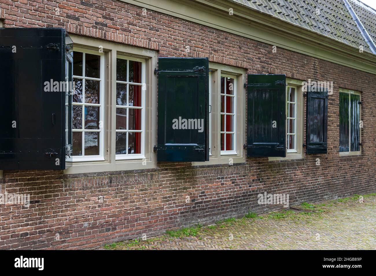 Grandes fenêtres sur la maison avec mur de briques et volets.C'est une église à Dordrecht, Hollande. Banque D'Images