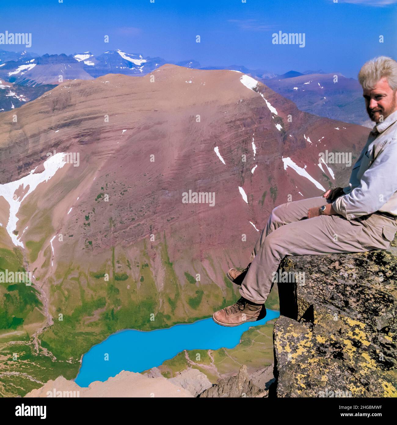 autoportrait de john lambing assis sur le bord de la tête du mont siyeh au-dessus du lac cracker dans le parc national du glacier, montana Banque D'Images