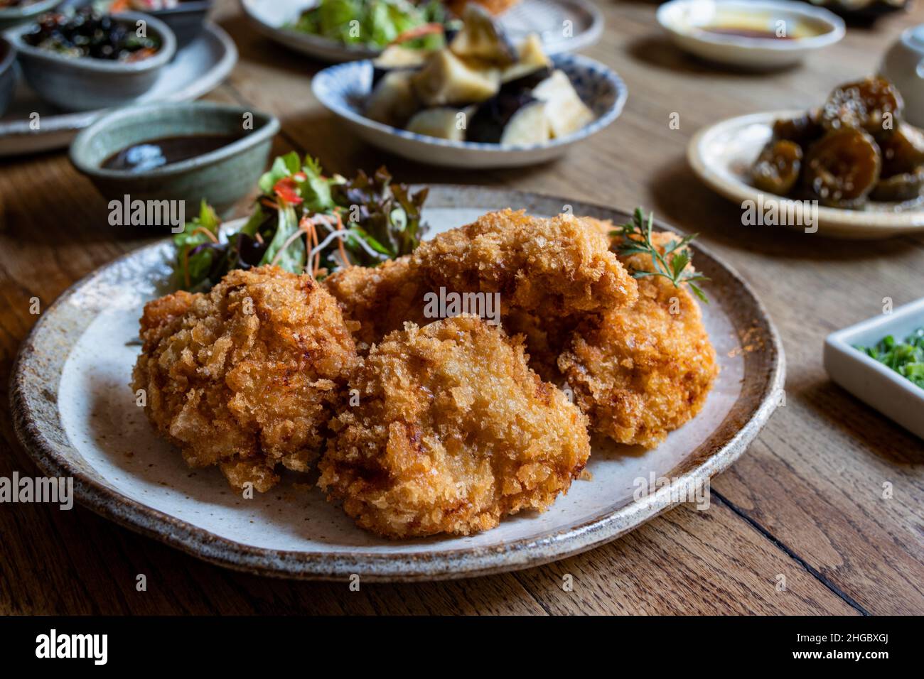 Le Tonkatsu ou le porc frits, un plat traditionnel japonais, avec divers autres plats japonais en arrière-plan. Banque D'Images