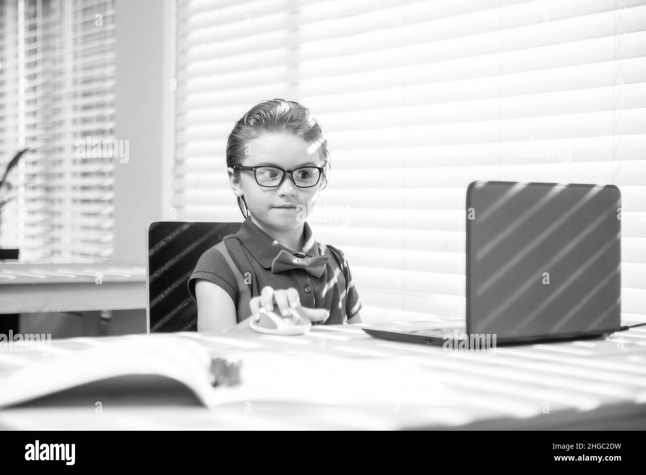 Première journée à l'école. Petit enfant mignon utilisant un ordinateur portable, étudiant l'ordinateur. Banque D'Images