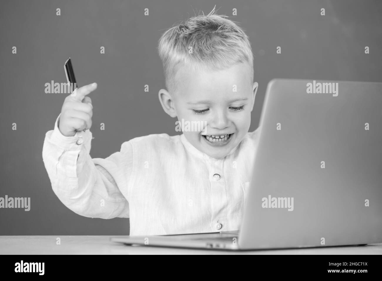 Un petit garçon enthousiaste qui utilise un ordinateur portable en classe scolaire.Programmation Genius enfant, formation informatique. Banque D'Images