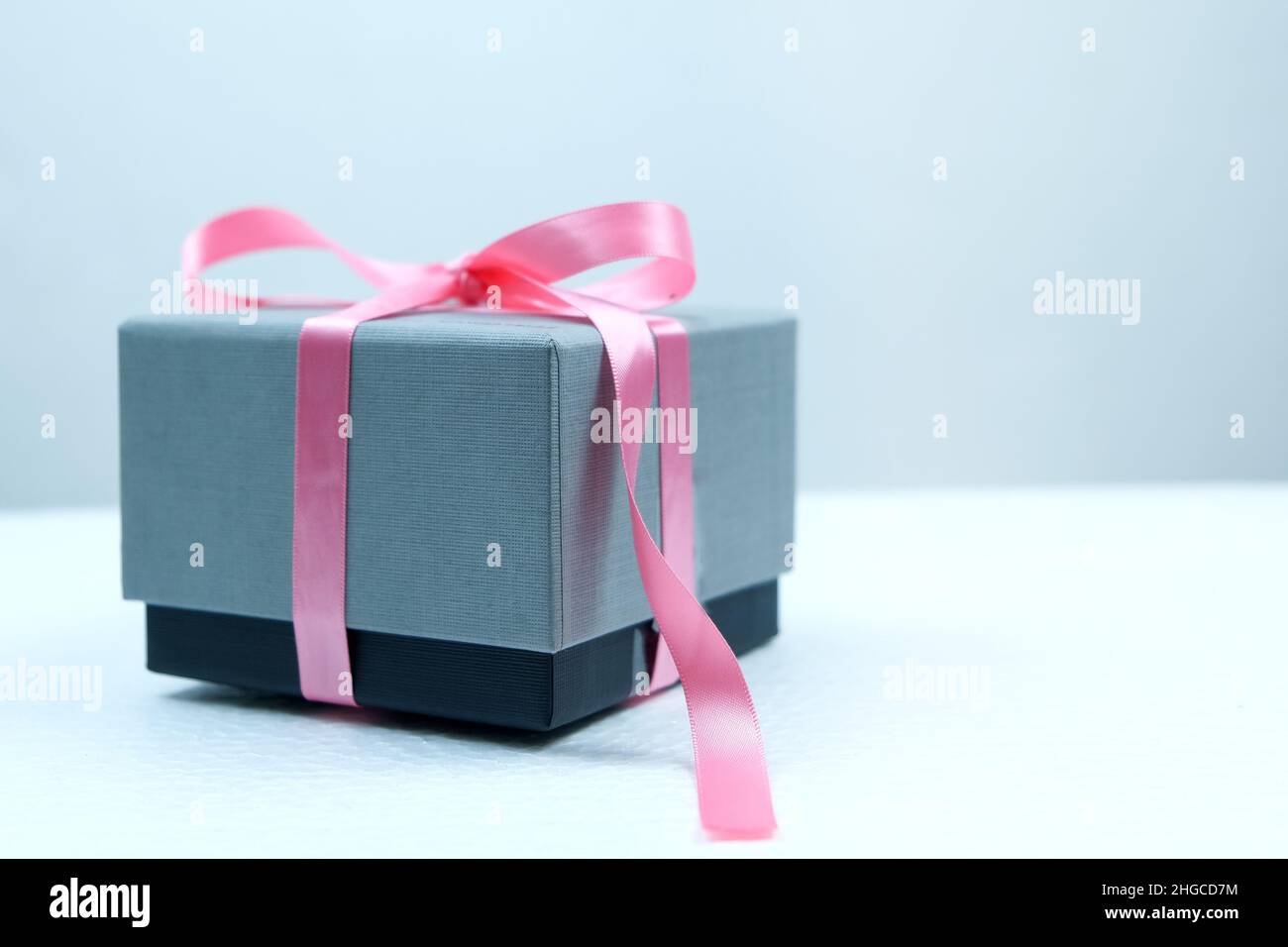 Boîte cadeau avec ruban rose le jour de la Saint-Valentin sur fond blanc Banque D'Images