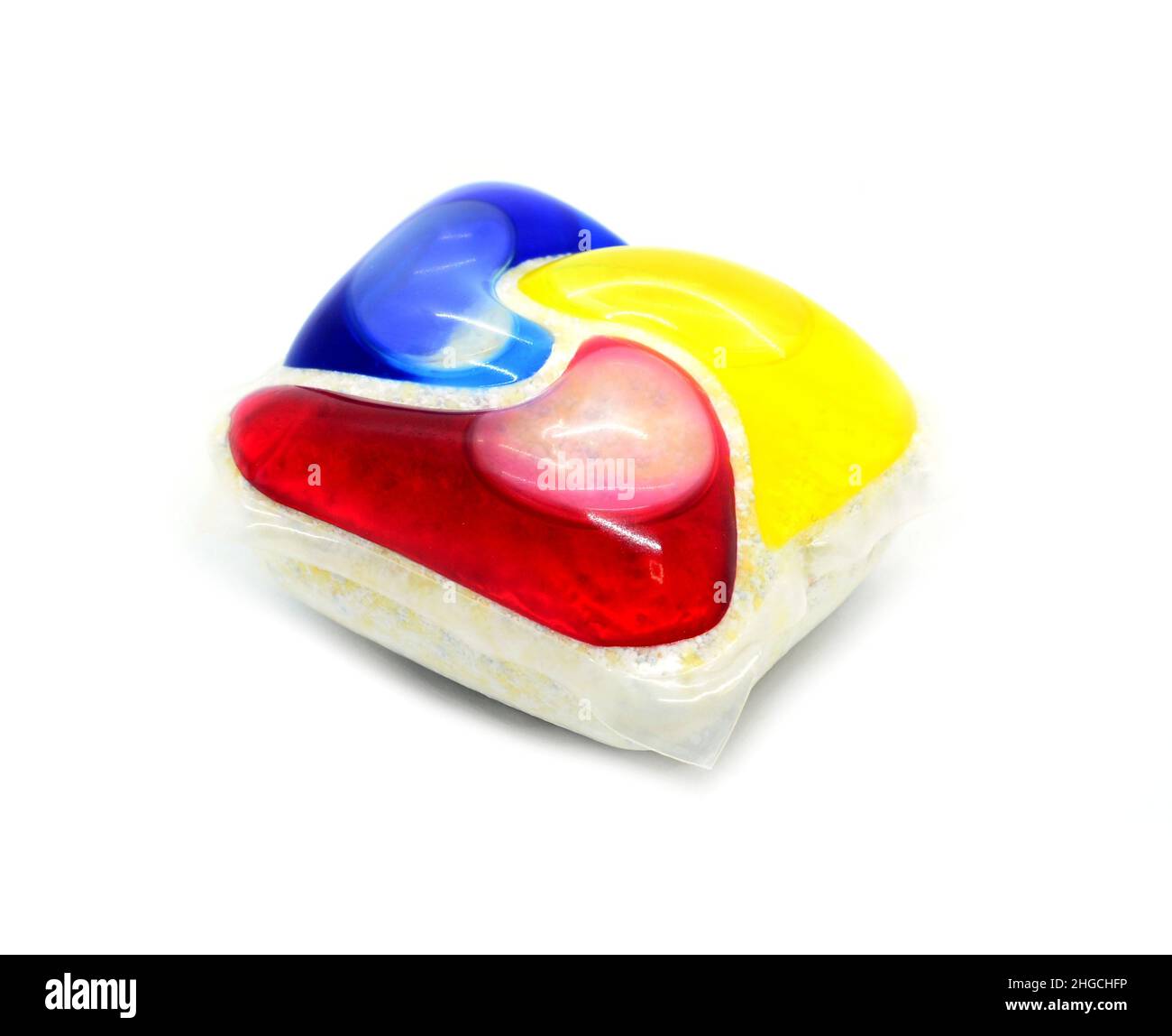 Un gros plan d'une dosette de détergent à lessive colorée sur fond blanc. Banque D'Images