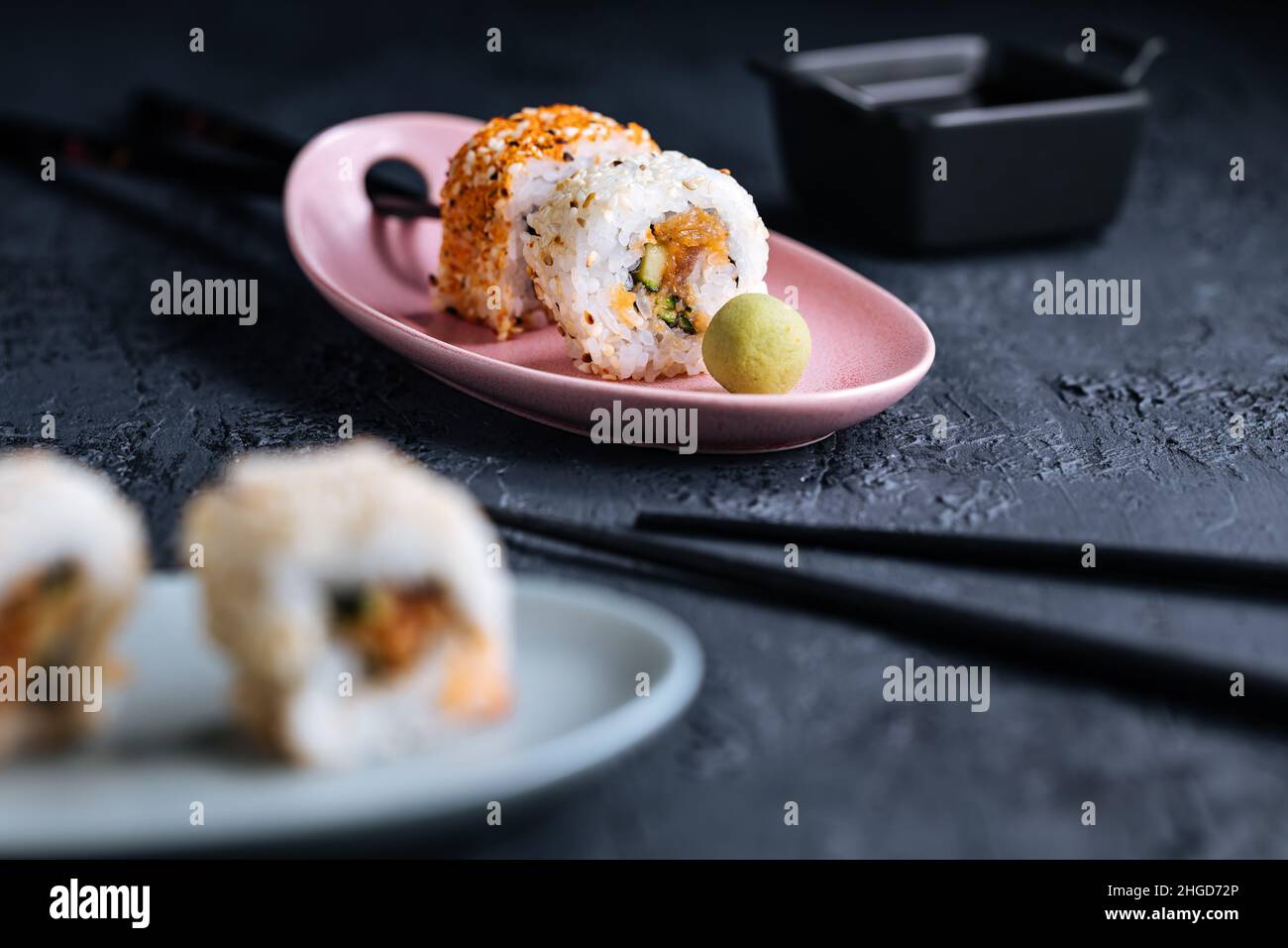 Divers petits pains à sushis sur fond sombre avec baguettes, wasabi et sauce soja.Cuisine traditionnelle japonaise de rue Banque D'Images