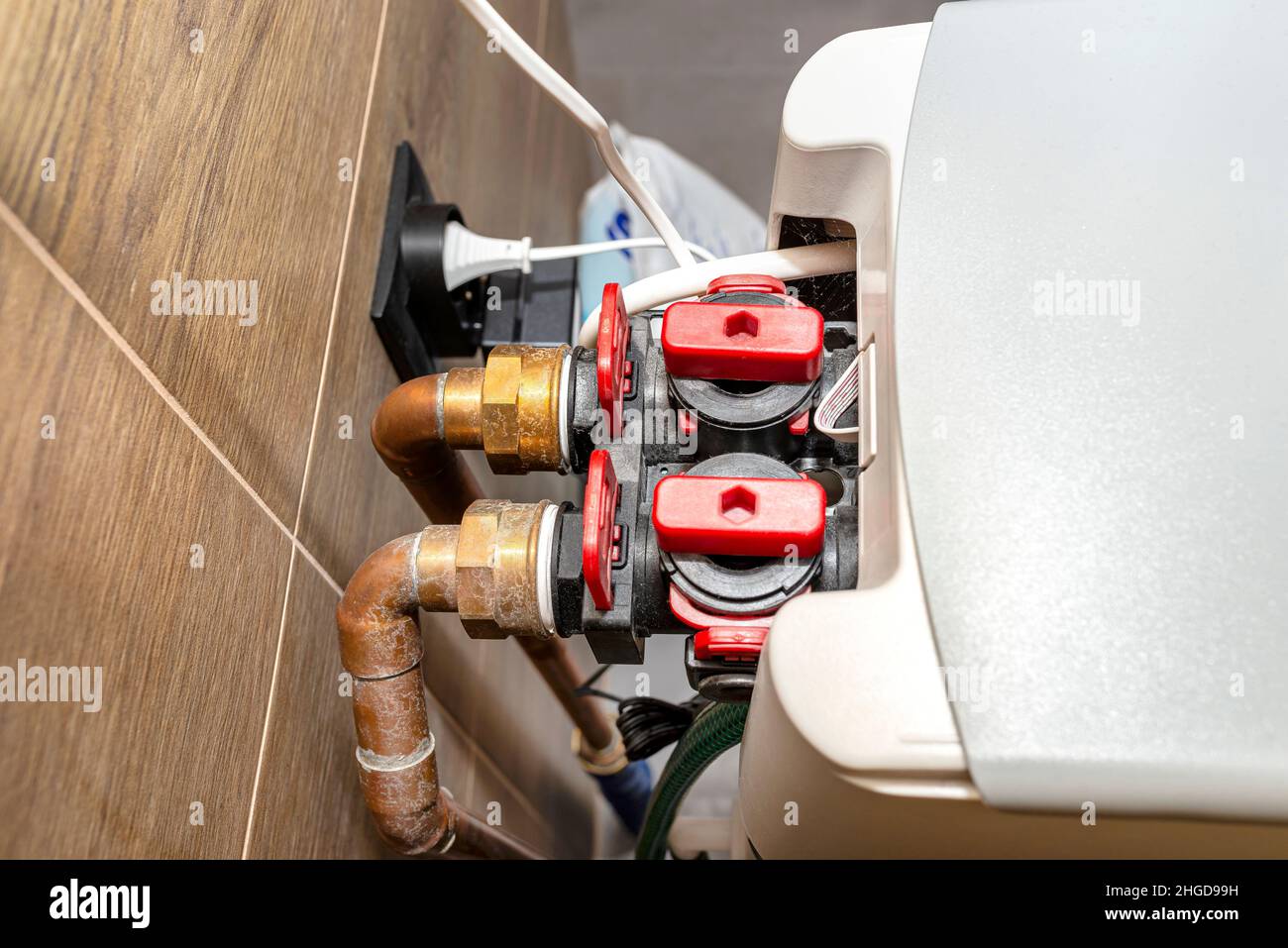 Tuyaux en cuivre alimentant en eau un adoucisseur d'eau stagnante domestique dans la chaufferie. Banque D'Images