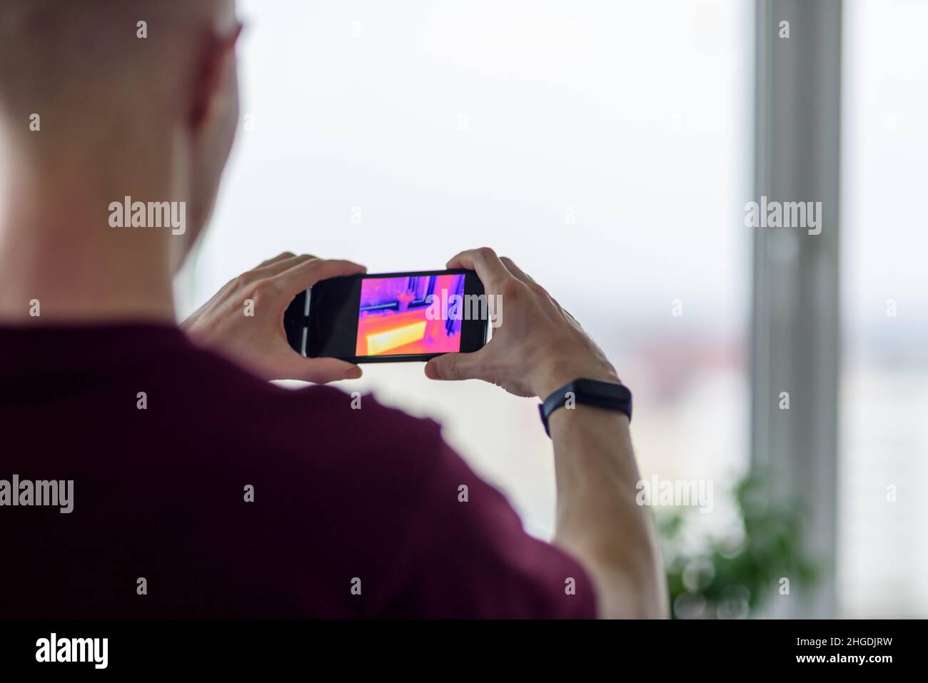 Personne effectuant la numérisation thermique ou l'imagerie de l'appartement avec l'application pour smartphone.Inspection thermographique pour vérifier l'efficacité de l'isolation Banque D'Images