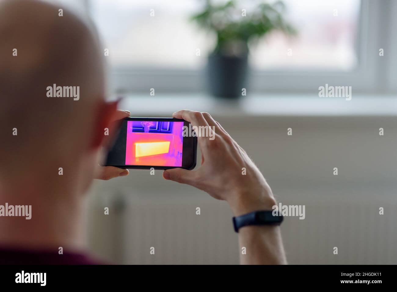 Personne effectuant la numérisation thermique ou l'imagerie de l'appartement avec l'application pour smartphone.Inspection thermographique pour vérifier l'efficacité de l'isolation Banque D'Images