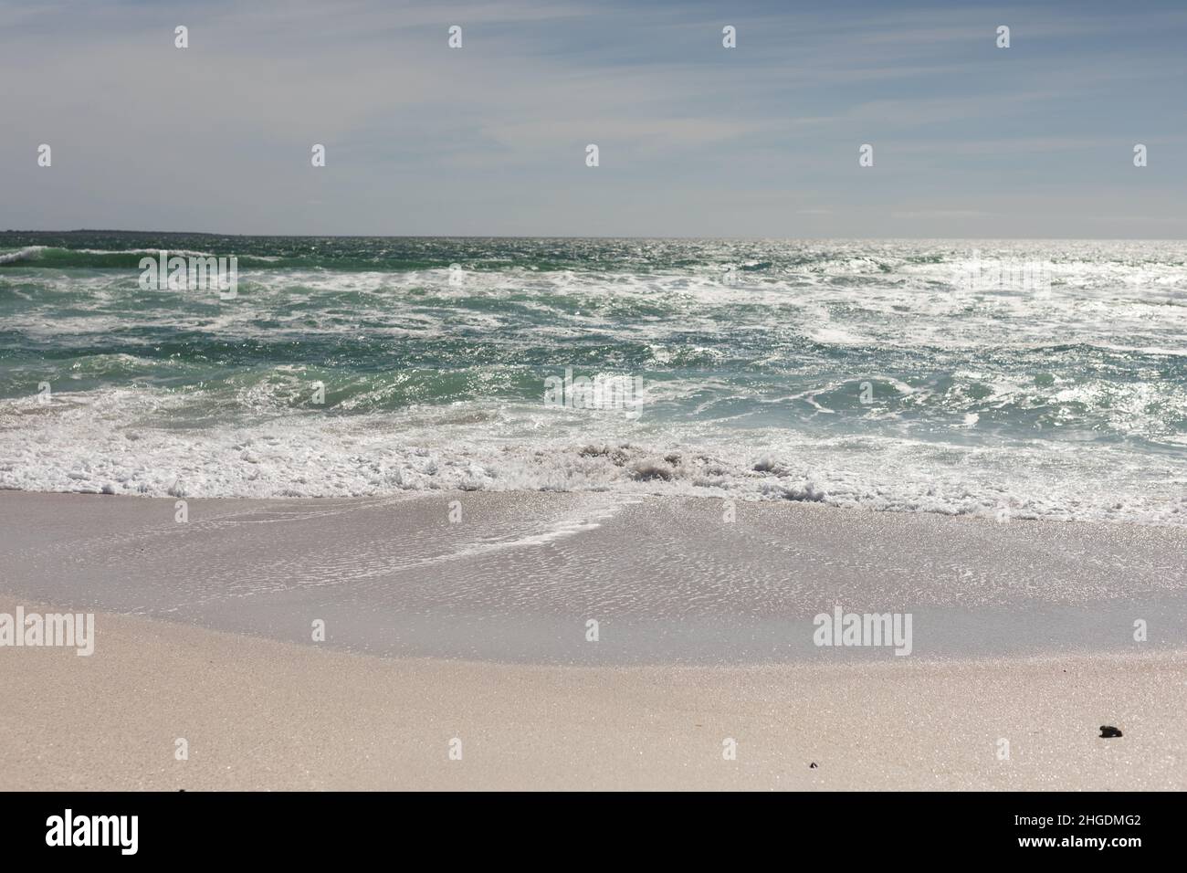 Les vagues s'écrasant sur la rive à la plage contre le ciel pendant la journée ensoleillée Banque D'Images
