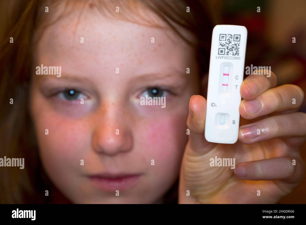 Onze ans / 11 ans année 7 étudiant / enfant / enfant / fille tenant son test de débit latéral / LFT / LFD / kit de dispositif de débit latéral ayant été testé positif (montrant deux lignes rouges) pour le coronavirus du virus COVID 19 pendant le test d'antigène à domicile, à Londres.ROYAUME-UNI.Le test de débit chinois (réalisé par le gène Orient en Chine) a détecté un virus dans l'échantillon d'écouvillon nasal prélevé dans le nez.(128) Banque D'Images