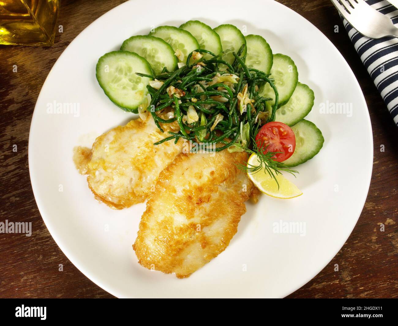 Filets de poisson frits à carabée surbaise enrobés d'œufs avec concombre et salade de pommes de terre Banque D'Images