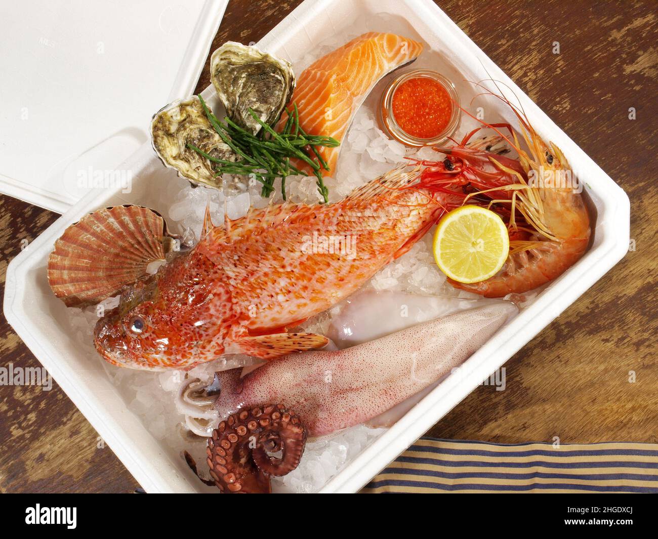 Boîte de transport avec poisson, fruits de mer et glace sur fond en bois Banque D'Images