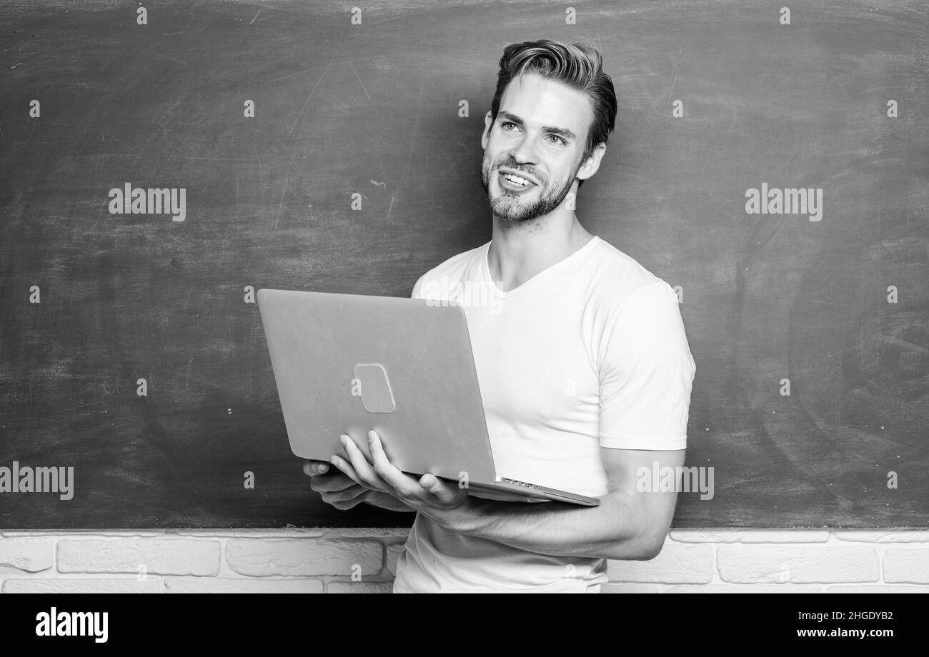 Les étudiants apprennent le monde numérique. Professeur d'école avec ordinateur portable. Le beau homme utilise la technologie moderne. Technologie numérique. Surfer sur Internet. En ligne Banque D'Images