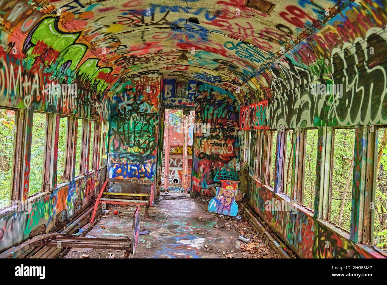 Un gros plan à l'intérieur d'un wagon abandonné avec des graffitis aux couleurs vives sur le chemin de halage du canal du fleuve Delaware à Lambertville NJ USA près de New Hope Pa. Banque D'Images
