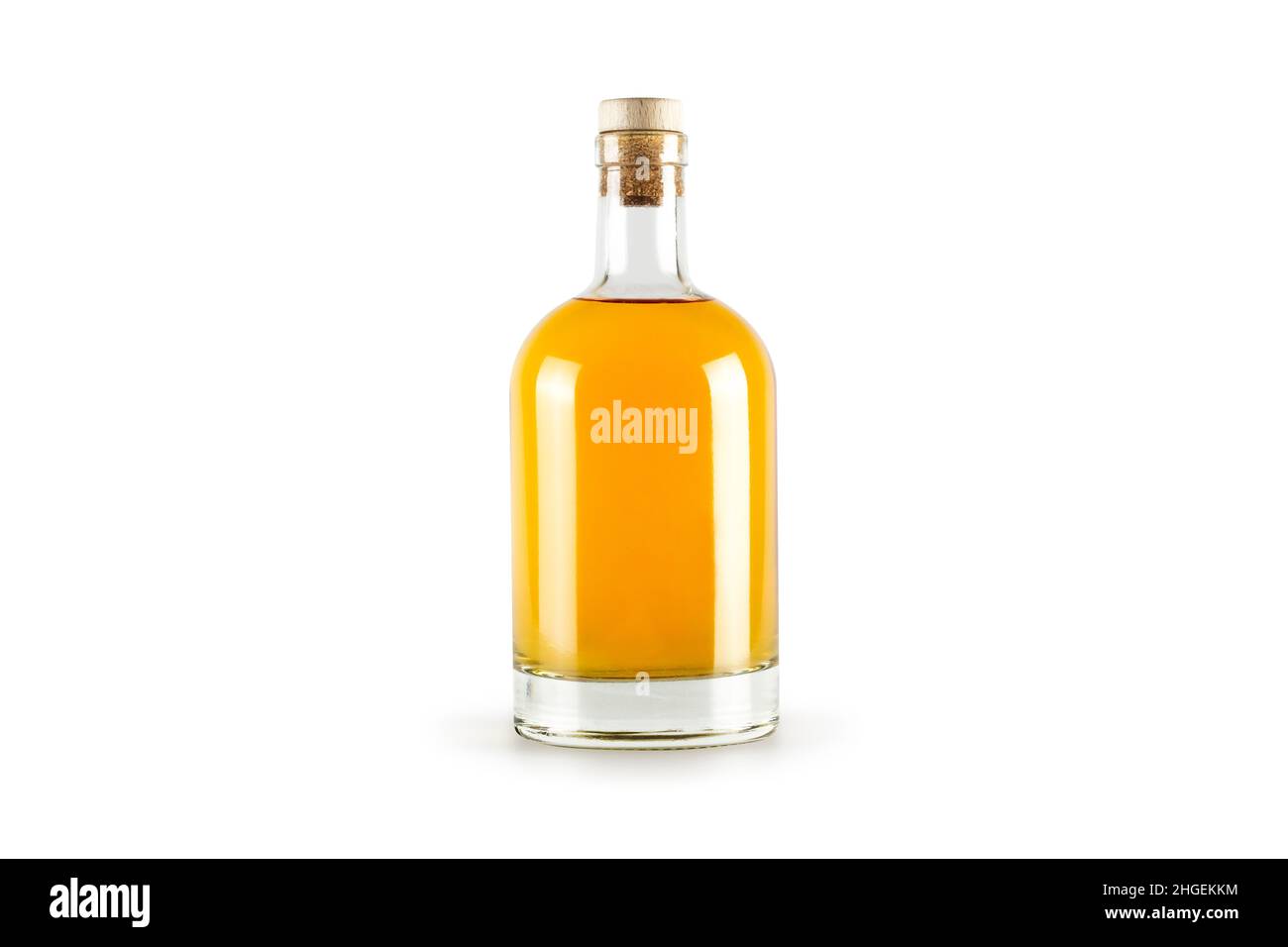Flacon transparent avec alcool doré à l'intérieur, isolé sur fond blanc. Banque D'Images