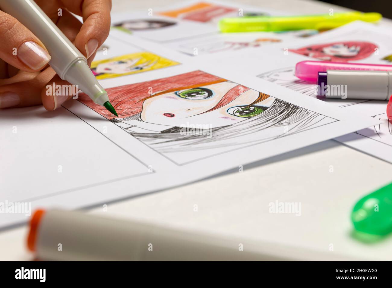 Un artiste dessine un storyboard d'un livre de BD animé.Style Manga.L'animateur de concepteur dessine avec une forme aquarelle avec un stylo les caractères d'un Banque D'Images