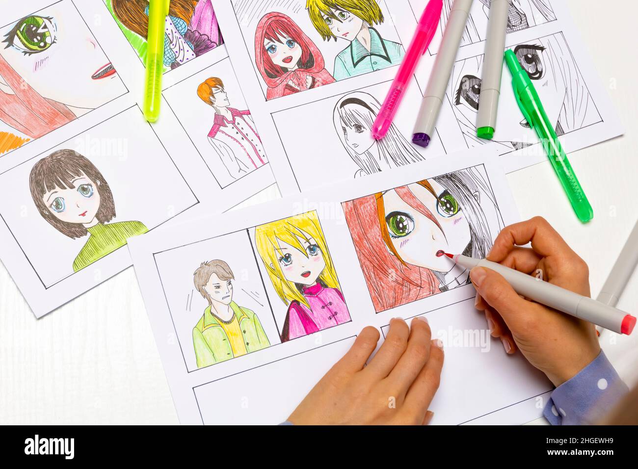 Un artiste dessine un storyboard d'un livre de BD animé.Style Manga.L'animateur de concepteur dessine avec une forme aquarelle avec un stylo les caractères d'un Banque D'Images