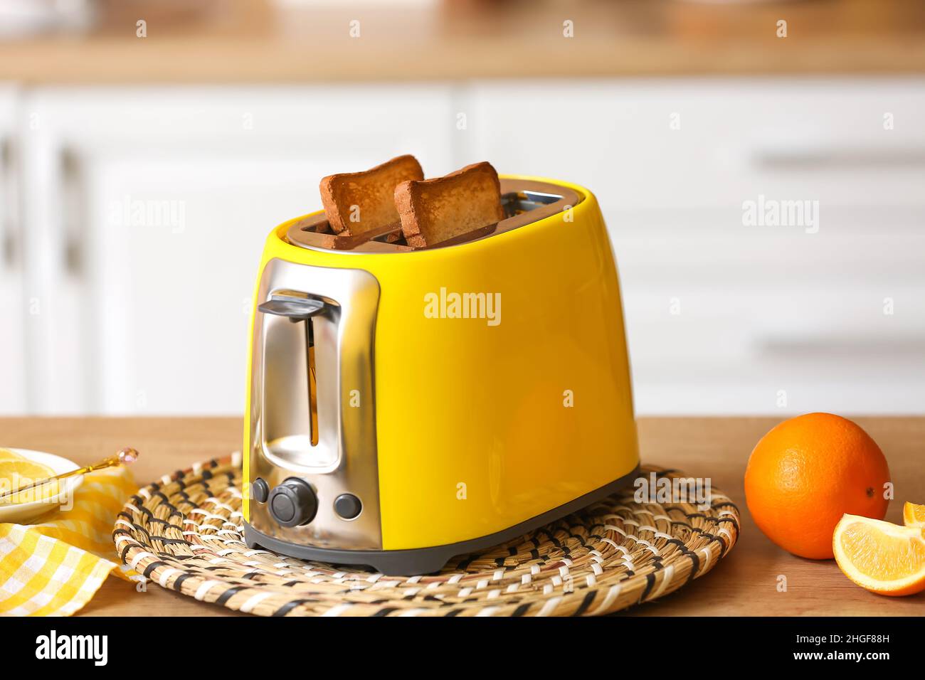 Grille-pain jaune avec pain et tranches d'orange sur la table dans la  cuisine Photo Stock - Alamy