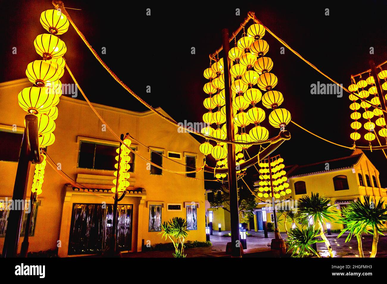 Des lanternes en soie jaune sont accrochées à des poteaux devant les magasins de Hoi an, parc à thème impressions. Banque D'Images